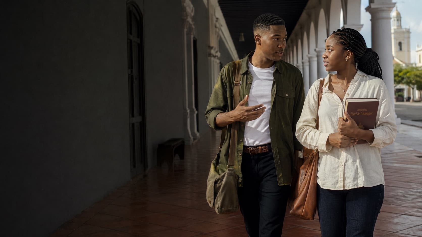 Two NIGA students walking through a colonnade in León, Nicaragua